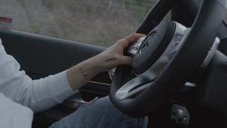 Man-driving-modern-car,-inside-view,-hand-on-steering-wheel-close-up