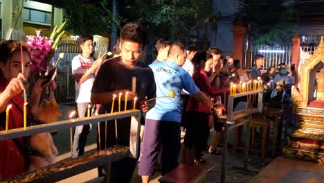 Los-Fieles-Encienden-Velas-Para-El-Día-De-Makha-Bucha,-Tailandia-Por-La-Noche