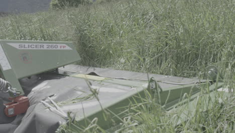 Tractor-slicer-mowing-lush-grass-on-fertile-alpine-meadow,-abundant-crop