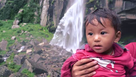 Madre-Sosteniendo-A-Un-Niño-Lindo-Durante-Su-Visita-A-La-Cascada-Jogini,-Manali