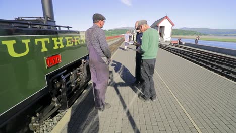 Dampflok-Ingenieur-Und-Feuerwehrmann-Unterhalten-Sich-Mit-Zugbegeisterten-Neben-Der-Lyd-Schmalspur-Dampfmaschine,-Ffestiniog-Railway,-Porthmadog-Harbour-Railway-Station,-Snowdonia,-Wales---Slomo-60fps