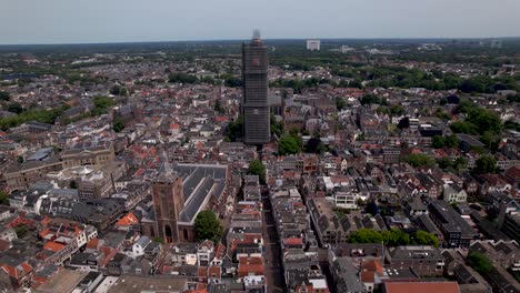 Enfoque-Aéreo-Panorámico-De-La-Torre-De-La-Catedral-Medieval-De-Dom-En-Andamios-En-El-Centro-De-La-Ciudad-Holandesa-De-Utrecht-Que-Se-Eleva-Sobre-El-Paisaje-Urbano-Contra-Un-Cielo-Azul-Amanecer-Y-Resplandor-Naranja-En-El-Horizonte