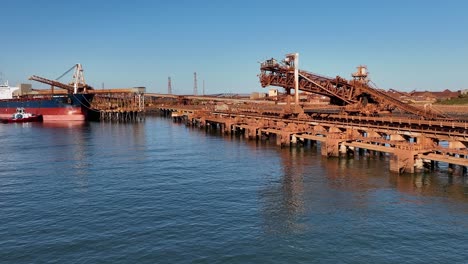 Un-Gran-Barco-Atracado-En-El-Cabo-Del-Puerto-Llenándose-De-Mineral-De-Hierro-Para-La-Exportación-Internacional