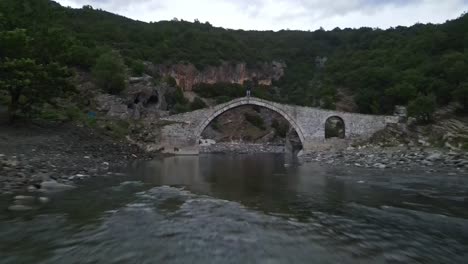 Low-angle-under-ottoman-arch-stone-bridge,-Vjose-river-Permet,-Albania