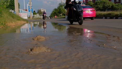 Wasser-Aus-Der-Unterirdischen-Rohrleitung-Verursacht-Überschwemmungen-Am-Straßenrand-Mit-Fahrzeugen,-Die-Auf-Der-Autobahn-Fahren