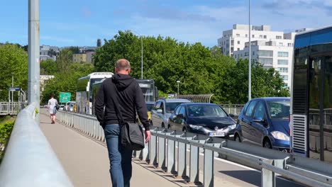 Mann-Mit-Schwarzer-Tasche-Geht-Auf-Dem-Bürgersteig-Entlang-Der-Durcheinander-Geratenen-Straße---Gdynia-Redłowo