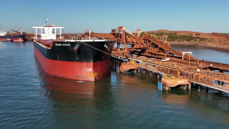 Un-Gran-Barco-Atracado-En-El-Cabo-Del-Puerto-Llenándose-De-Mineral-De-Hierro-Para-La-Exportación-Internacional