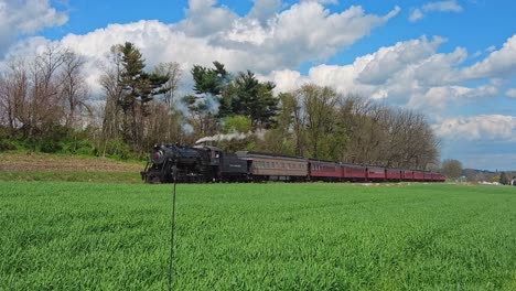 Vista-De-Un-Tren-De-Pasajeros-De-Vapor-Que-Se-Acerca-Soplando-Humo-Y-Vapor-En-Un-Hermoso-Día-De-Primavera