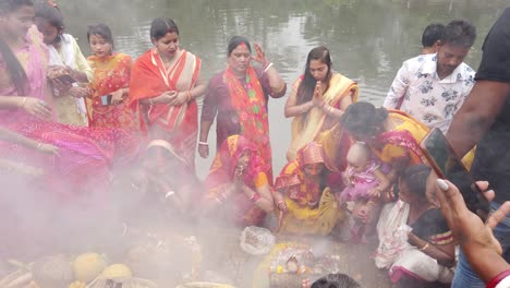 Primer-Plano-De-Las-Personas-Que-Realizan-Rituales-Para-La-Ceremonia-De-Boda-Hindú-Cerca-Del-Río-Ganga-Con-Humo-De-Fuego-En-Kolkata