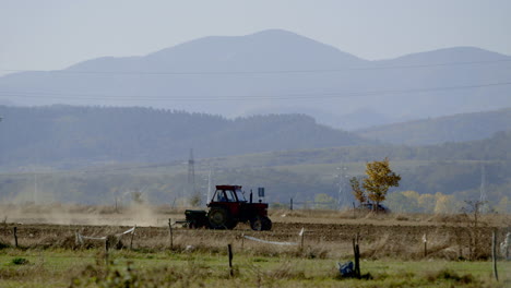 An-old-tractor-sows-seeds-on-a-dusty-field-in-rural-Romania