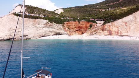 La-Gente-Se-Relaja-En-Un-Yate-De-Lujo-En-La-Playa-De-Porto-Katsiki,-Lefkada,-Grecia---Antena