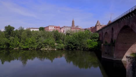 Cars-crossing-the-Old-Bridge-and-approaching-Saint-James-cathedral-and-city-center,-Aerial-rising-approach-shot