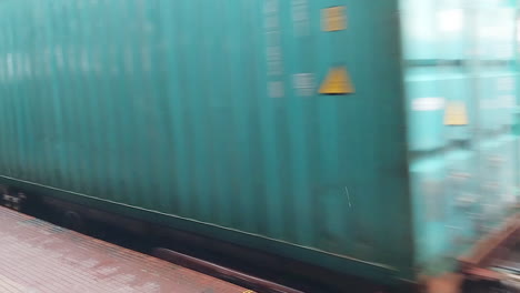 Ein-Güterzug-Fährt-Am-Bahnsteig-Vorbei,-Während-Menschen-Daneben-Gehen