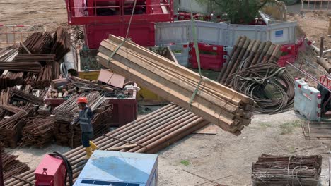 Un-Trabajador-De-Ingeniería-Chino-Ayuda-A-Una-Grúa-Mientras-Tira-De-Una-Pila-De-Tablas-De-Madera-En-Un-Proyecto-De-Construcción-En-Desarrollo-En-Hong-Kong