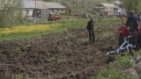 Hombres-En-El-Campo-Con-Tractor-Agrícola-Arando-Durante-El-Día-En-La-Aldea-De-Moliti,-Georgia