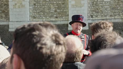 Guía-Turístico-De-La-Ciudad-De-Londres-Con-Traje-Tradicional-Explicando-Hechos-Históricos-Para-Turistas-En-La-Torre-De-Londres,-Yeoman-En-Acción