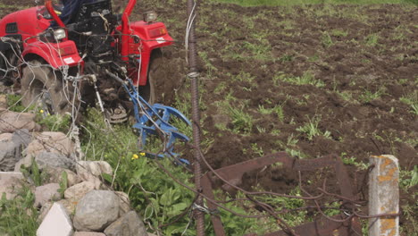 Farmer-plowing-soil-in-his-small-field-nearby-idyllic-Georgian-village