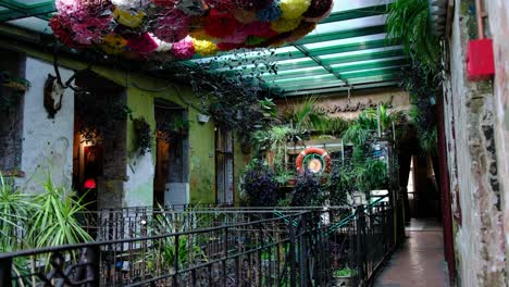 Beautiful-woman-views-historic-Ruin-Bars-in-the-heart-of-Budapest-in-Hungary,-Europe---Pubs-built-in-graffiti-covered-abandoned-and-war-torn-spaces,-indoor-plant-life---Smooth-Panning-Left-4K-30FPS