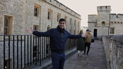 Joven-Sonriendo-A-La-Cámara-Y-Extendiendo-Sus-Manos-Durante-Un-Recorrido-En-La-Torre-De-Londres,-Inglaterra