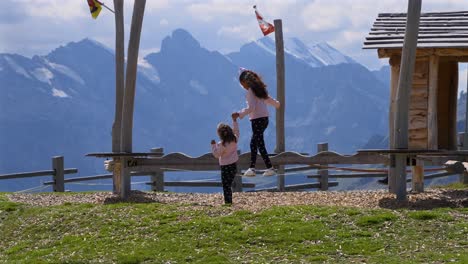 Hermanas-Gemelas-Ayudándose-Mutuamente-En-Una-Viga-De-Equilibrio-En-Un-Parque-Suizo