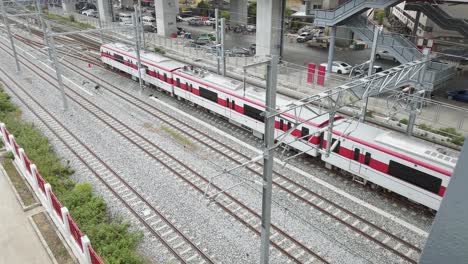 Außenansicht-Des-Zuges,-Der-Sich-Der-Bahnsteigstation-SRT-Red-Line-Nähert,-Mit-Wartenden-Menschen-In-Bangkok,-Thailand