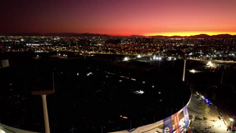 Increíble-Puesta-De-Sol-Naranja-Sobre-El-Horizonte-Nocturno-De-Santiago,-Chile-Que-Revela-El-Estadio-Nacional