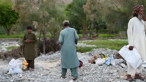 Pakistanisches-Männchen-Mit-Weißer-Plane-Unter-Dem-Arm-Während-Der-Flutwelle,-Um-Hilfe-Zu-Leisten