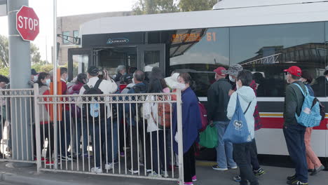 Turistas-Asiáticos-Haciendo-Fila-Para-Abordar-Un-Autobús-En-Australia,-Cámara-Lenta