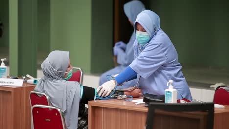 Doctor-using-sphygmomanometer-with-stethoscope-checking-blood-pressure-to-a-patient-in-the-hospital