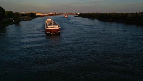 Aerial-View-Above-Oude-Maas-With-Maxima-Liquid-Cargo-Ship-Bathed-In-Sunset-Light-Making-Approach