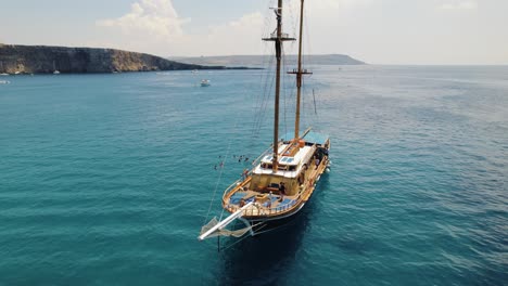 Drohne-Zieht-Sich-Vom-Boot-In-Der-Blauen-Lagune,-Malta-Zurück