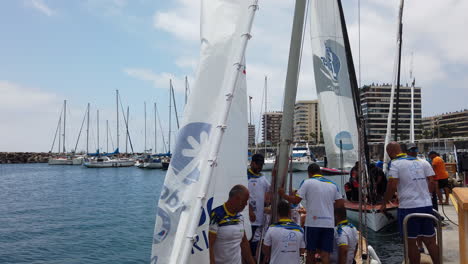 Latin-sail-boat-where-its-sailors-prepare-the-sails-to-set-sail-from-the-marina,-on-a-sunny-day-in-Las-Palmas-de-Gran-Canaria