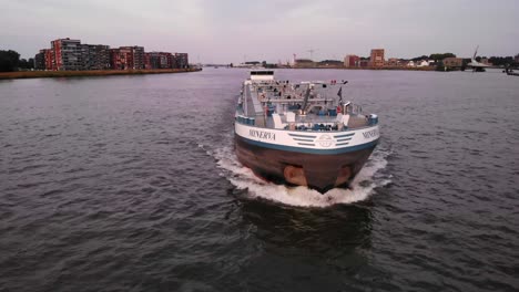 Cargo-Tank-Barge,-Crude-Oil-Tanker-Waterway-Vessel-Navigating-Along-River-Canal-in-Dordrecht-Netherlands,-Aerial-Tracking-View-of-Nautical-Traffic-and-Coastline-Maritime-Navigation