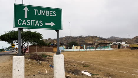 Para-Indicar-La-Dirección-De-Bocapan,-Tumbes-Y-Casitas-En-Perú,-Se-Ha-Montado-Un-Letrero-De-Dirección-Verde-Sobre-Dos-Pilares-Blancos