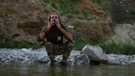 Langhaariger-Bärtiger-Pakistanischer-Mann,-Der-Gesicht-Und-Bart-Mit-Flusswasser-Wäscht