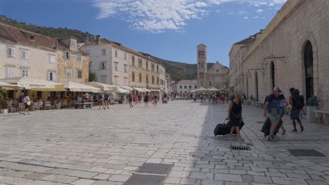 Vista-Panorámica-En-Cámara-Lenta-De-Los-Viajeros-En-La-Plaza-Principal-De-Hvar,-Croacia