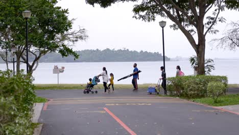 Familia-Caminando-Por-El-Camino-Costero-Con-Vistas-Al-Paisaje-Marino-En-El-Pueblo-De-Changi-En-Singapur