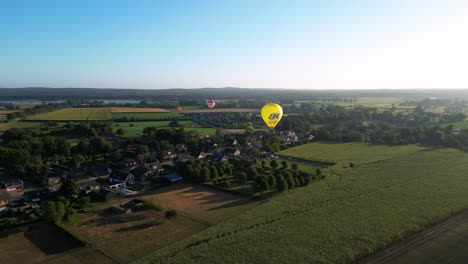 Luftaufnahmen-Von-Heißluftballons,-Die-Während-Des-Morgendlichen-Sonnenaufgangs-über-Die-Ländliche-Landschaft-In-Den-Niederlanden-Fliegen