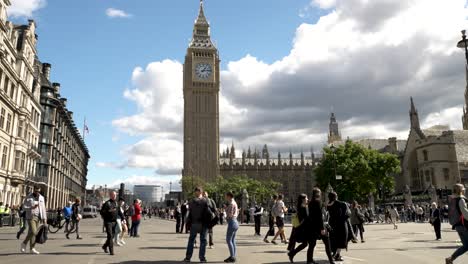 Low-angle-shot-of-tourists-and-locals-walking-along-Parliament-Square,-London,-UK-at-daytime