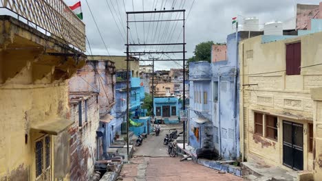 Motorbike-Pulling-Over-In-Jodhpur-Dilapidated-Buildings-Street,-India