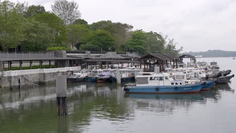 Fernsicht-Auf-Passagiere,-Die-In-Richtung-Bumboats-Gehen,-Die-An-Der-Anlegestelle-Des-Dorfes-Changi-In-Singapur-Festgemacht-Sind