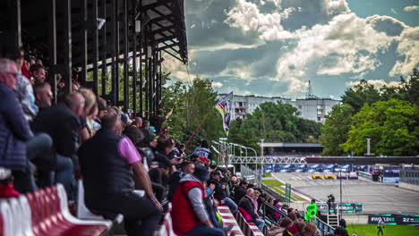 Statische-Aufnahme-Von-Sportzuschauern,-Die-In-Einem-Offenen-Stadion-Sitzen,-Um-An-Einem-Bewölkten-Tag-Die-Rx-rallye-cross-weltmeisterschaft-In-Riga,-Lettland,-Zu-Verfolgen