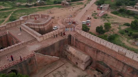 Die-Drohne-Macht-Eine-Luftaufnahme-Der-Umerkot-Festung,-Auf-Der-Menschen-Die-Architektonische-Pracht-Der-Festung-Bewundern