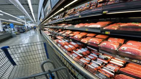 Pov,-Während-Er-Einen-Karren-Durch-Den-Walmart-Schiebt,-Vorbei-An-Der-Rindfleischabteilung---Steaks-Und-Hackfleisch