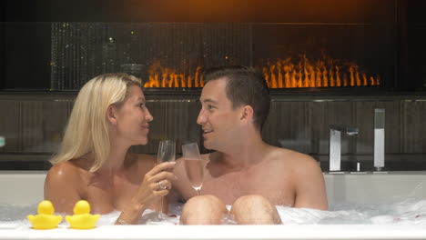 Feliz-Pareja-Joven-Bebiendo-Vino-Blanco-Mientras-Habla-Y-Se-Relaja-En-El-Jacuzzi