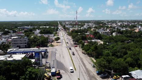 Un-Día-Soleado-Y-Brillante-Mientras-Los-Autos-Conducen-A-Través-De-Tulum-Mexico-En-Una-Larga-Carretera,-Antena