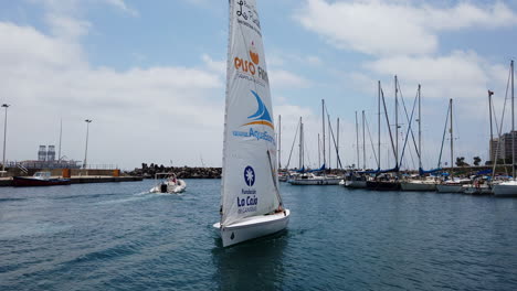 small-lateen-sailboat-arrives-in-port-and-the-sailors-man-the-sails