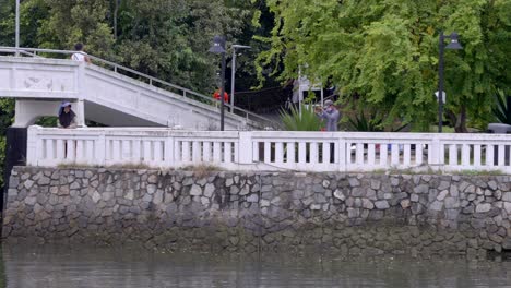 Asiatisches-Paar,-Das-Am-Fluss-Changi-In-Der-Nähe-Des-Fährterminals-Changi-Point-In-Singapur-Fischt