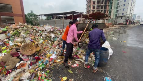 Trabajadores-Vaciando-Carro-De-Basura-En-El-Sitio-De-Basura-Al-Lado-De-La-Carretera-En-Dhaka,-Bangladesh