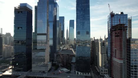 An-aerial-view-of-Hudson-Yards-with-the-Empire-State-Building-in-the-distance-on-a-sunny-morning